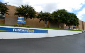Exterior view of a Pellissippi State Technical Community College building with a sign and a driveway leading uphill.